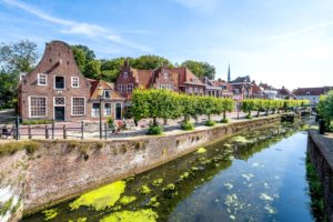Een oever in Amersfoort, op de kade staan historische huizen. De foto is vanaf het water genomen.
